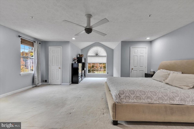 carpeted bedroom featuring ceiling fan and a textured ceiling