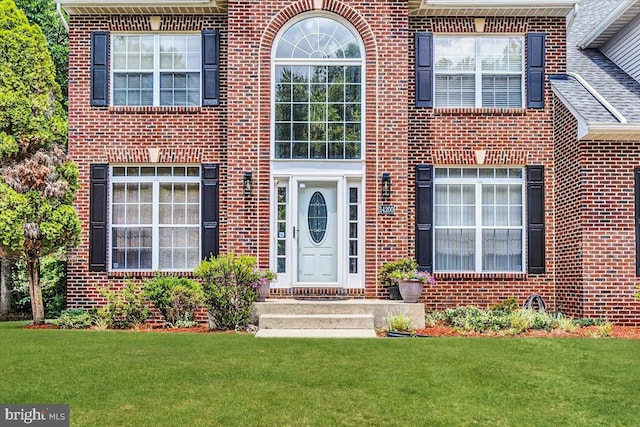 view of exterior entry with a yard