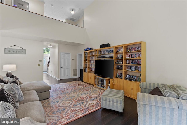 living room featuring dark wood-type flooring and a high ceiling