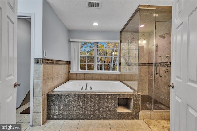 bathroom with shower with separate bathtub, tile walls, tile patterned floors, and a textured ceiling