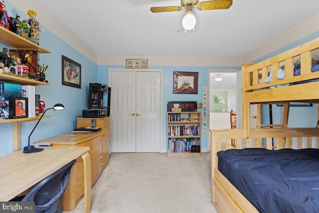 bedroom with light colored carpet, ceiling fan, and a closet