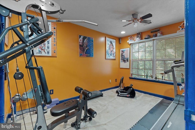 workout area featuring ceiling fan and a textured ceiling