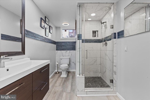 bathroom featuring vanity, toilet, an enclosed shower, and hardwood / wood-style floors