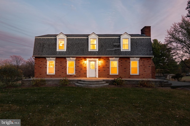 cape cod house with a lawn