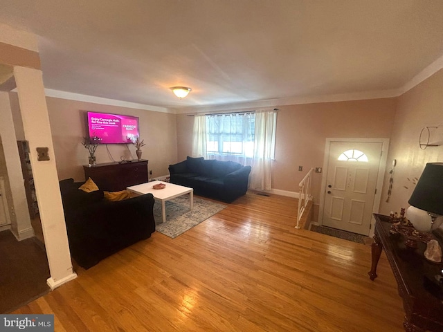 living room featuring wood-type flooring and ornamental molding