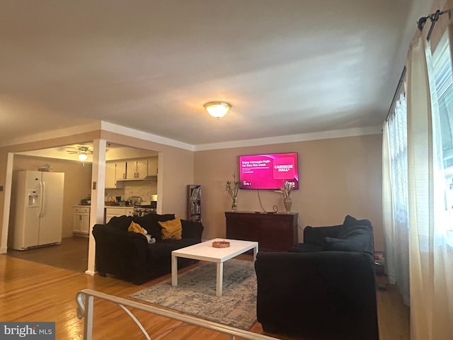 living room featuring wood-type flooring and ceiling fan