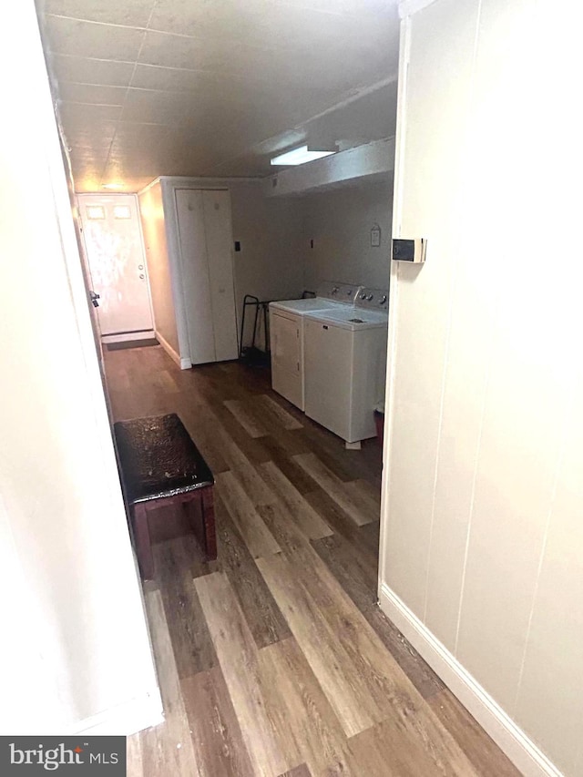 corridor featuring wood-type flooring and washing machine and dryer