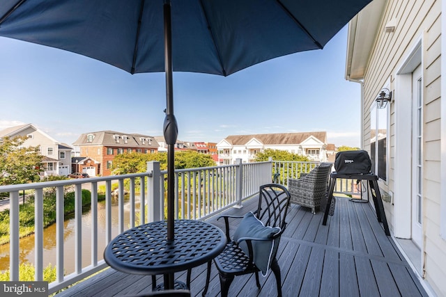 wooden deck featuring a grill and a water view