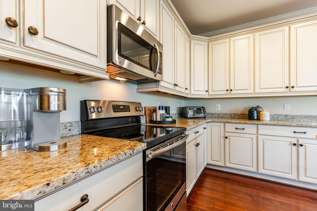 kitchen with appliances with stainless steel finishes, dark hardwood / wood-style floors, and light stone counters