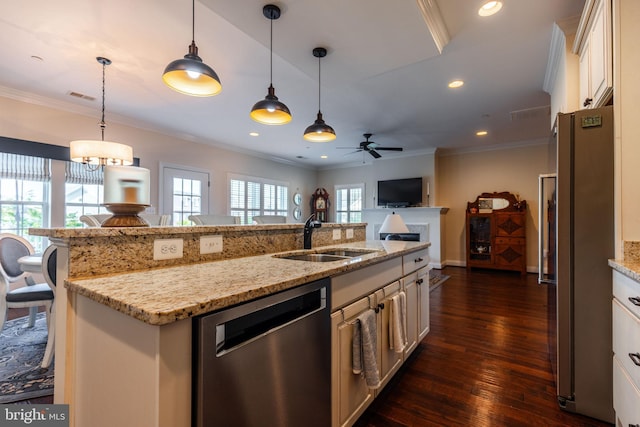 kitchen with ceiling fan, sink, decorative light fixtures, a kitchen island with sink, and appliances with stainless steel finishes