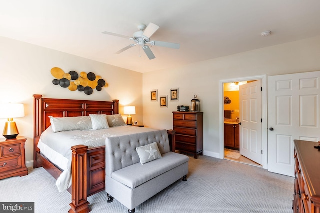 bedroom with ceiling fan, ensuite bathroom, and light carpet