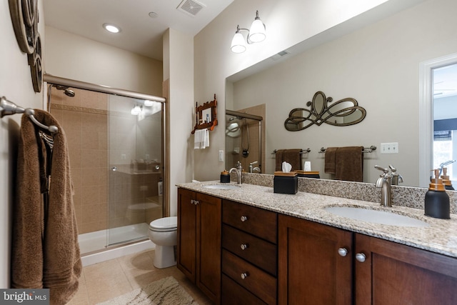 bathroom with tile patterned flooring, vanity, toilet, and a shower with door