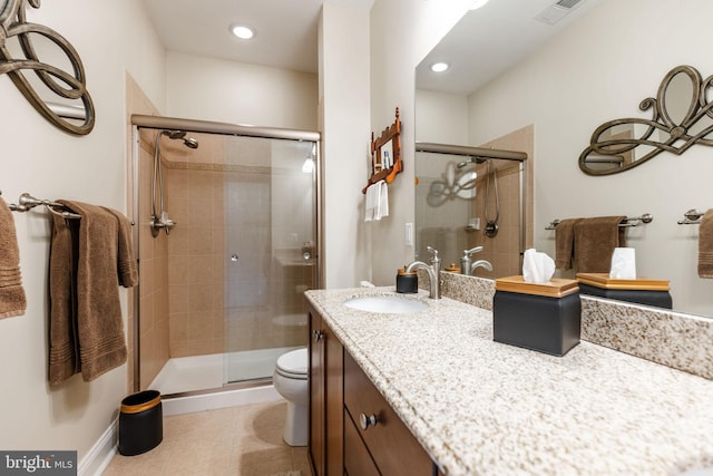 bathroom featuring tile patterned flooring, a shower with door, vanity, and toilet