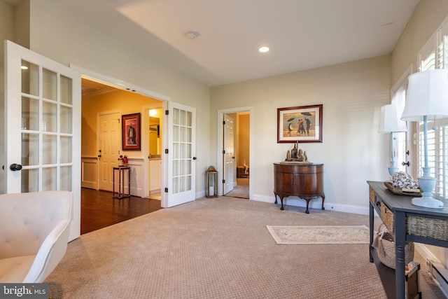 living area featuring french doors and dark colored carpet