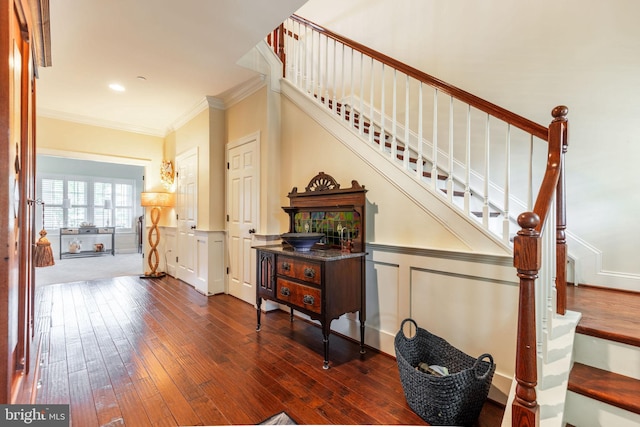 stairs featuring wood-type flooring and crown molding