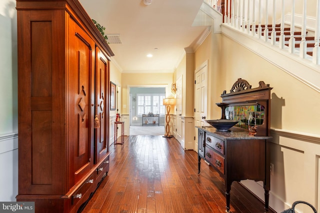 corridor featuring ornamental molding and dark wood-type flooring