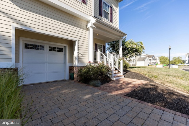 entrance to property with covered porch and a garage