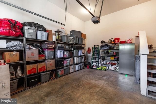 garage with stainless steel fridge and a garage door opener