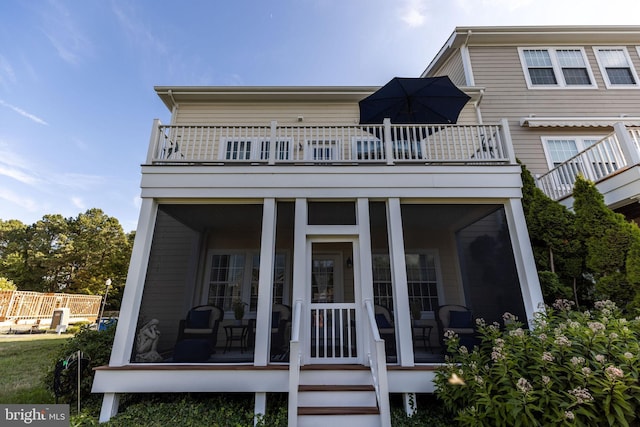 back of property featuring a balcony and a sunroom