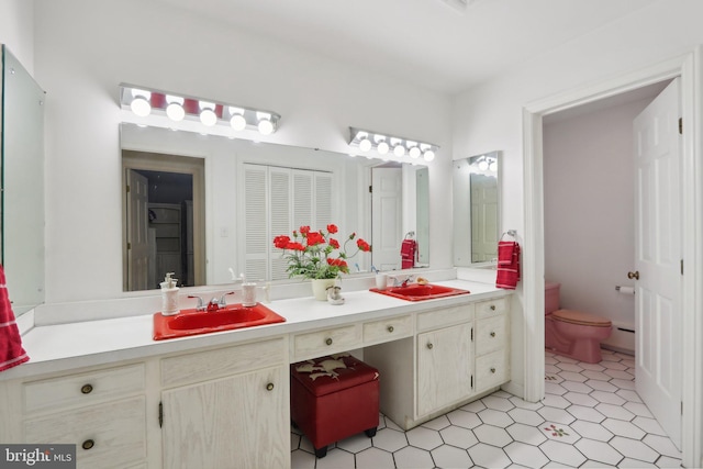 bathroom with toilet, vanity, and baseboard heating