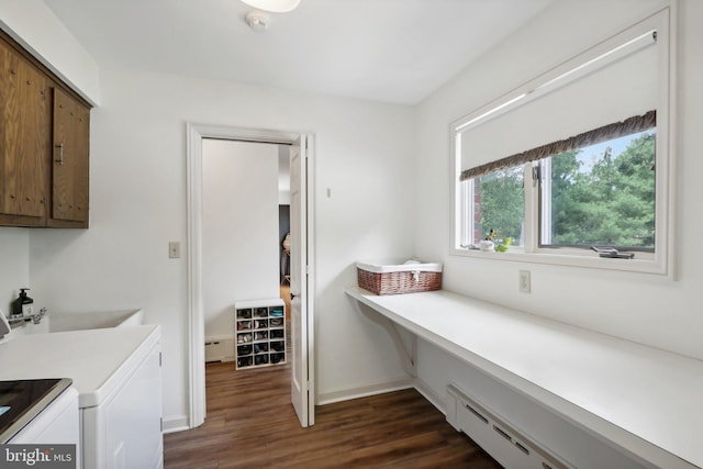 interior space featuring dark wood-type flooring, cabinets, a baseboard heating unit, and separate washer and dryer