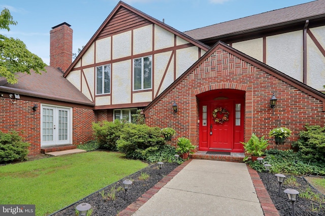 property entrance with a lawn