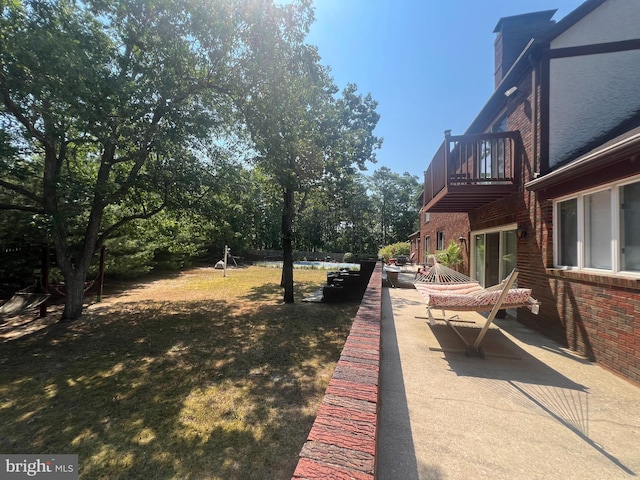 view of yard featuring a balcony and a patio area