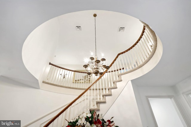 staircase featuring an inviting chandelier