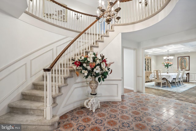 staircase featuring a high ceiling and a notable chandelier