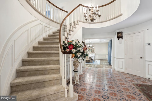 entryway featuring an inviting chandelier and a towering ceiling