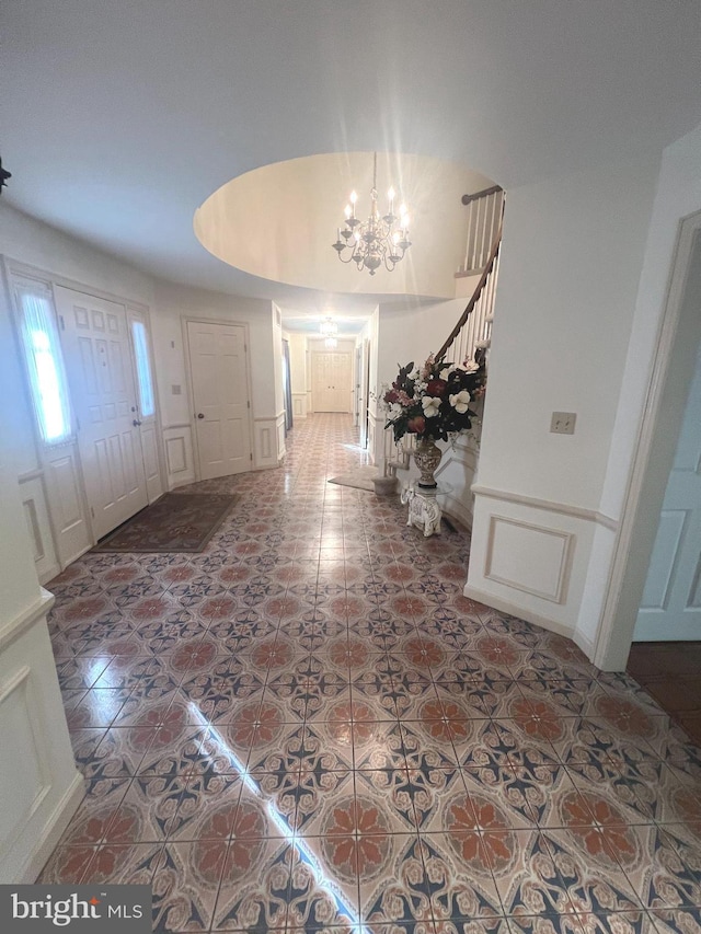 tiled foyer entrance with a notable chandelier