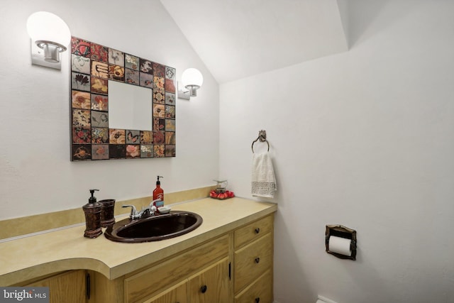 bathroom featuring vaulted ceiling and vanity