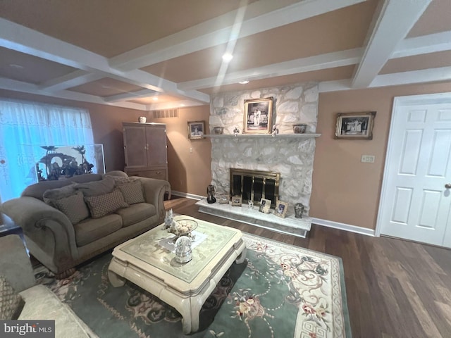 living room with wood-type flooring, beam ceiling, a stone fireplace, and coffered ceiling