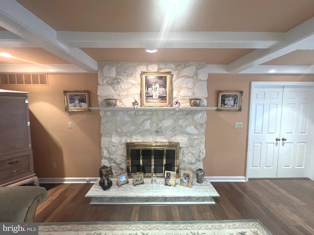 interior details with wood-type flooring, beamed ceiling, and a stone fireplace