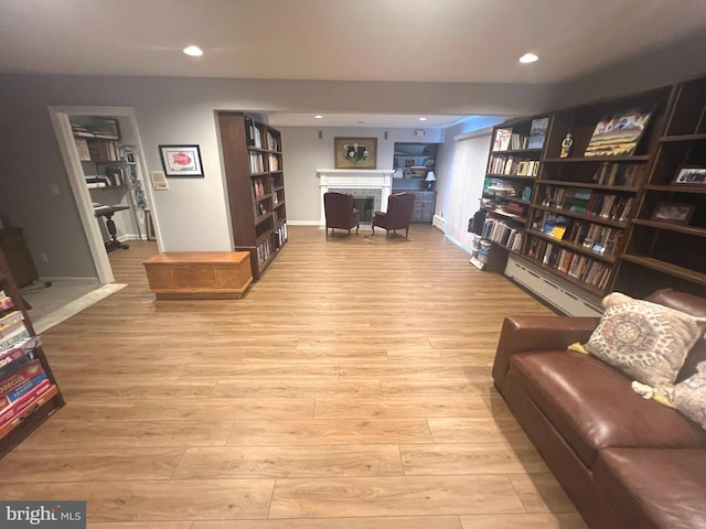 living room with light hardwood / wood-style floors and a baseboard heating unit