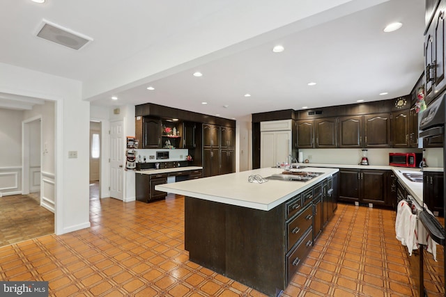 kitchen featuring dark brown cabinetry, gas stovetop, and a kitchen island