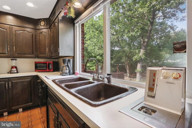 kitchen featuring dark brown cabinetry and sink