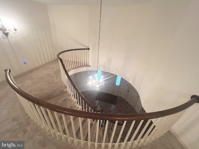 staircase with carpet and a notable chandelier