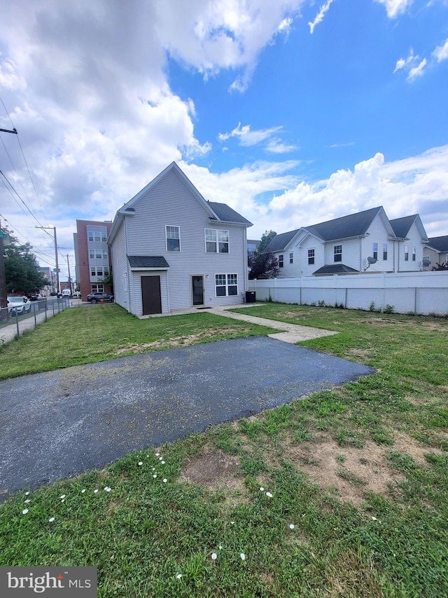 rear view of house featuring a garage and a yard