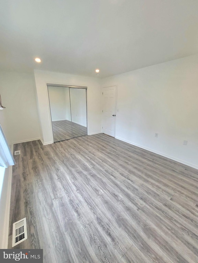 unfurnished bedroom featuring hardwood / wood-style flooring and a closet