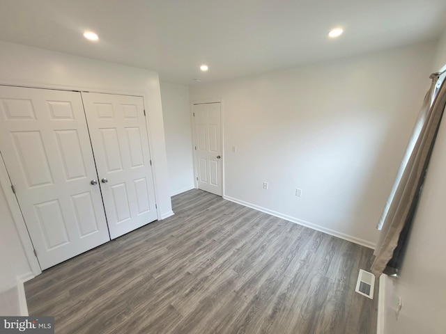 unfurnished bedroom featuring a closet and wood-type flooring