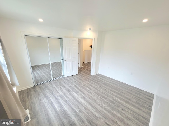 unfurnished bedroom with a closet and hardwood / wood-style floors