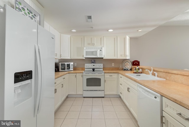 kitchen with light tile patterned floors, sink, and white appliances