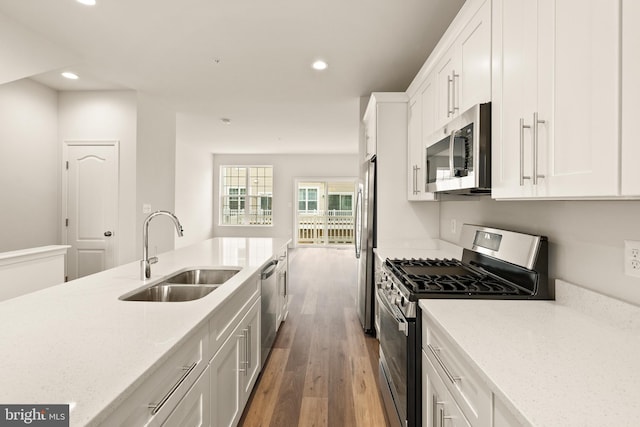 kitchen featuring sink, white cabinetry, light stone counters, appliances with stainless steel finishes, and dark hardwood / wood-style floors