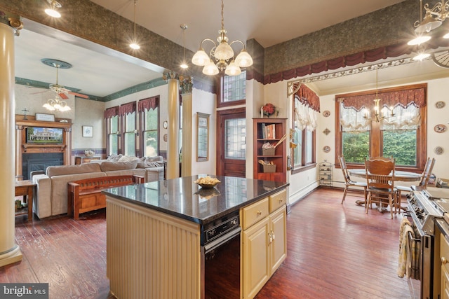 kitchen with ceiling fan with notable chandelier, a healthy amount of sunlight, a center island, and dark wood-type flooring