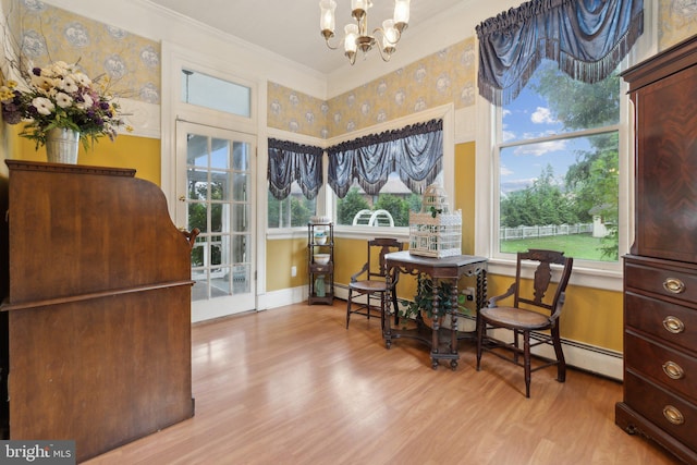 sitting room with light wood-type flooring, an inviting chandelier, baseboard heating, and ornamental molding