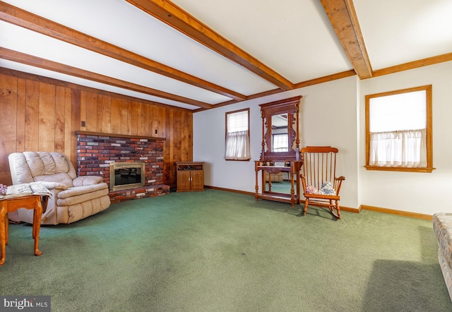 sitting room with a fireplace, beam ceiling, carpet flooring, and wood walls