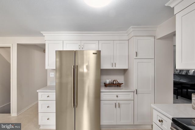 10712 Freds Oak Ct, Burke, VA 22015 - kitchen with high end refrigerator, light countertops, white cabinetry, and light tile patterned floors