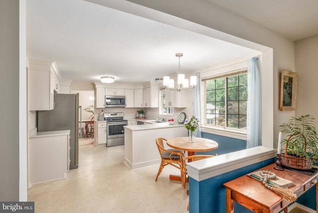10712 Freds Oak Ct, Burke, VA 22015 - kitchen featuring appliances with stainless steel finishes, a sink, a chandelier, a peninsula, and light countertops
