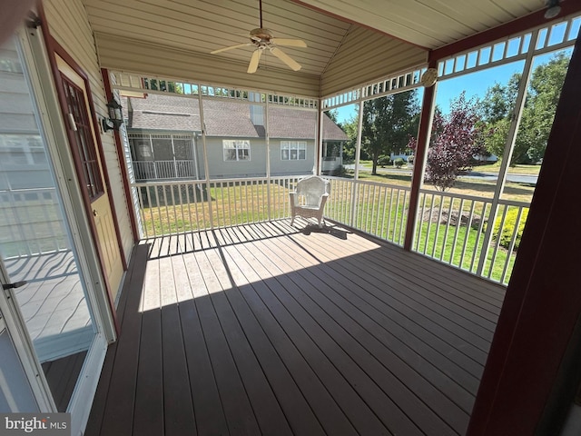 wooden terrace featuring ceiling fan, a yard, and a porch